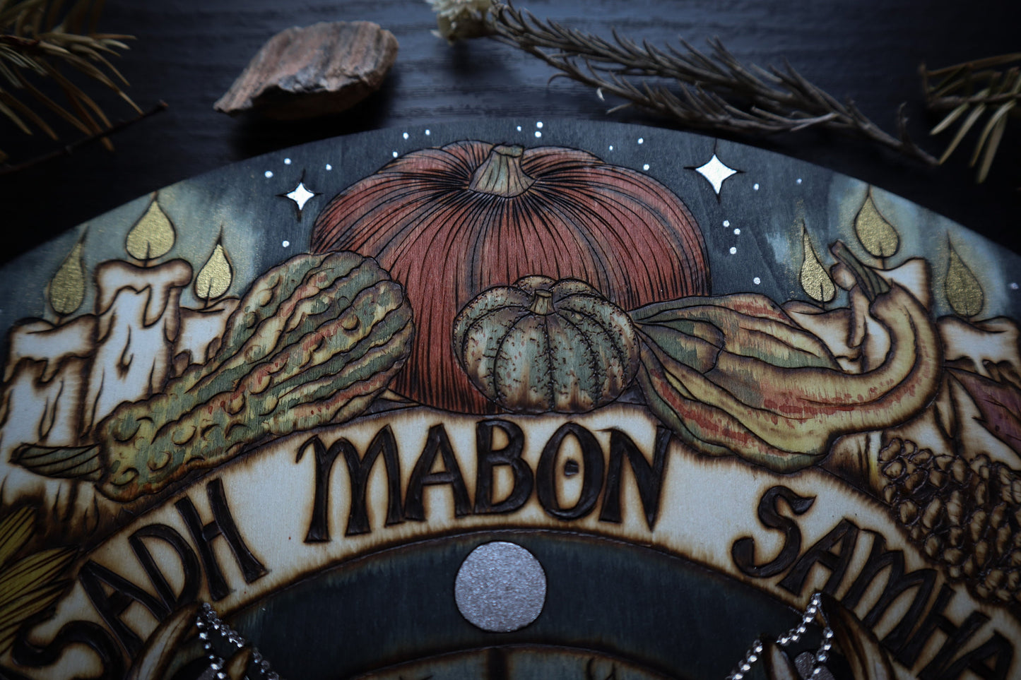 Witchy mabon autumn equinox wheel of the year for pagan altar woodburned decor with gourds, candles, sunflowers, apples, fall leaves.