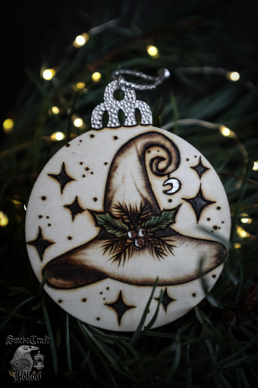 Add the magick to your witchmas tree with this witch’s hat ornament with sparkly silver moon accent, measuring 7cm with silver twine for hanging on your whimsically enchanted Yule tree this winter solstice season!
Pyrography art handcrafted in Suffolk, U.K.
Www.smokecrafthollow.com