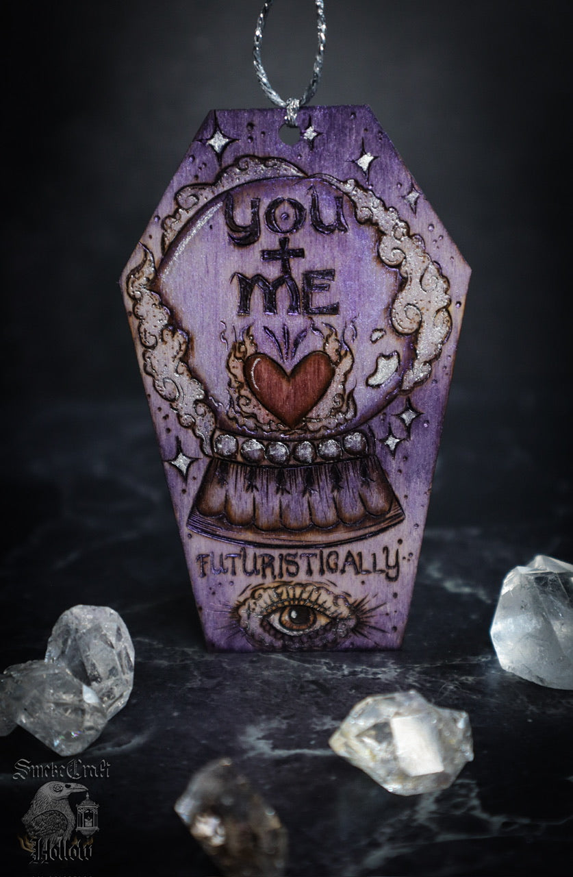 Spooky cute gothic witchy valentine’s day woodburned art decor on wooden casket coffin ornament hanging with crystal ball, heart, and all seeing eye. Handmade by Smokecraft Hollow