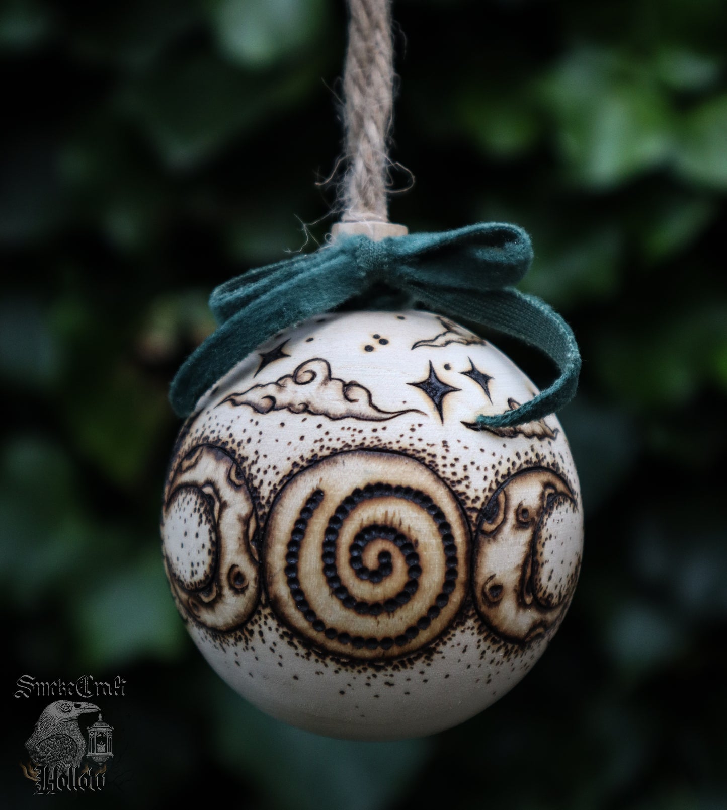 Pagan yule wooden bauble tree ornament with triple goddess symbol and woodland scene complete withe velvet green bow, clouds, and stars for witchmas home decor.