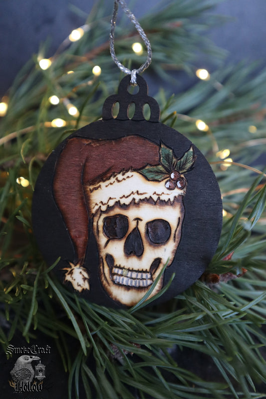 Adorn your spookmas tree with this Santa skull spooky Christmas woodburned bauble ornament &nbsp;measuring 7cm with sparkly silver hanging twine. This unalive Santa &nbsp;is ready to haunt your tree and scare off any would-be Yule gift thieves, gold tooth and all!

Hand pyrography in Suffolk, U.K. www.smokecrafthollow.com
