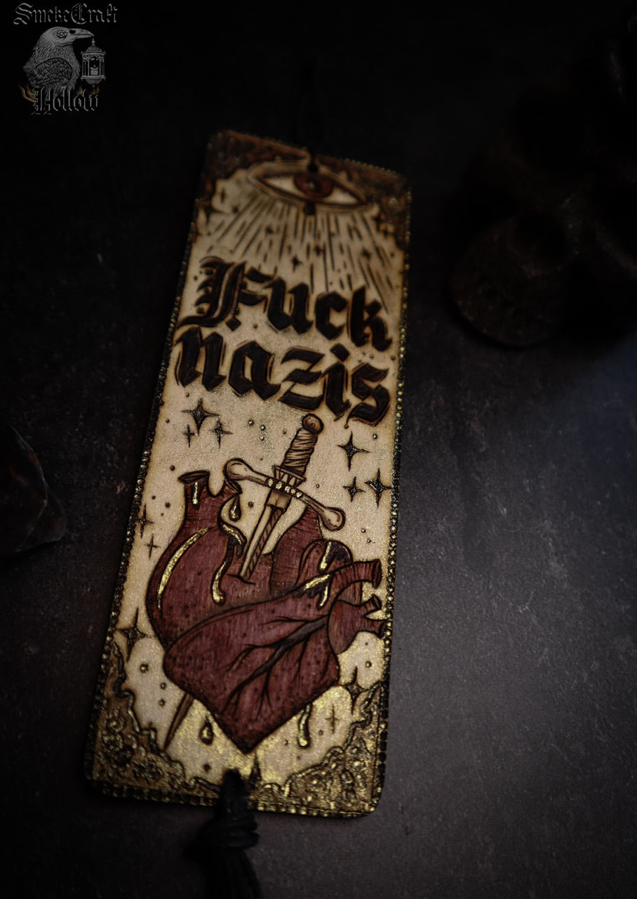 Fuck nazis woodburned wall banner artwork decor for ant—racist anti-facist activist decor by smokecraft hollow with all seeing eye and anatomical heart in medieval gothic style And gold and red colouring