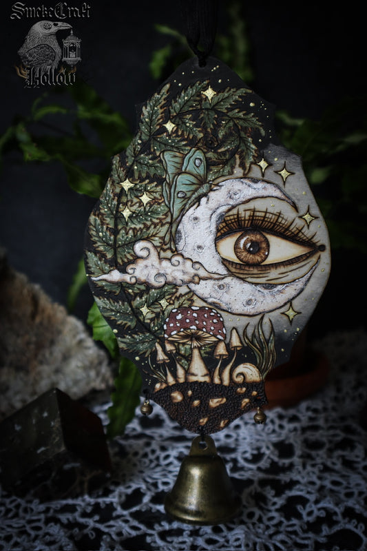 Whimsigoth art depicting a celestial garden with moon, luna moth, all seeing eye, fern, mushrooms for witch bells to hang on door. 