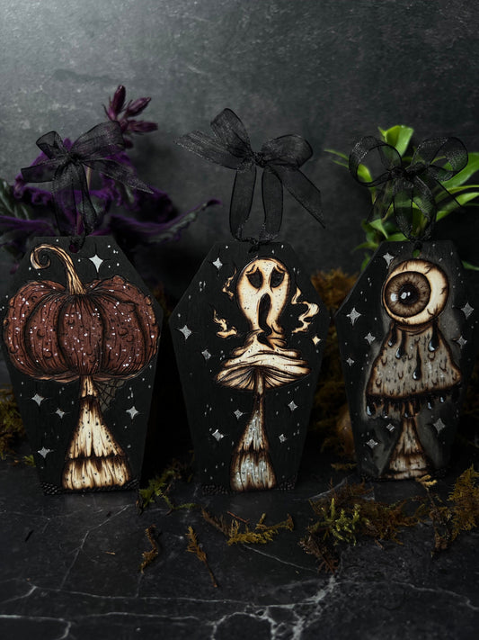 Spooky hand woodburned spooky ghostie, pupkin, and eyeball mushroom coffin shaped ornaments by smokecraft hollow